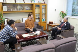 Alex and Matsu-san speak with Wazuka's town mayor in his office.