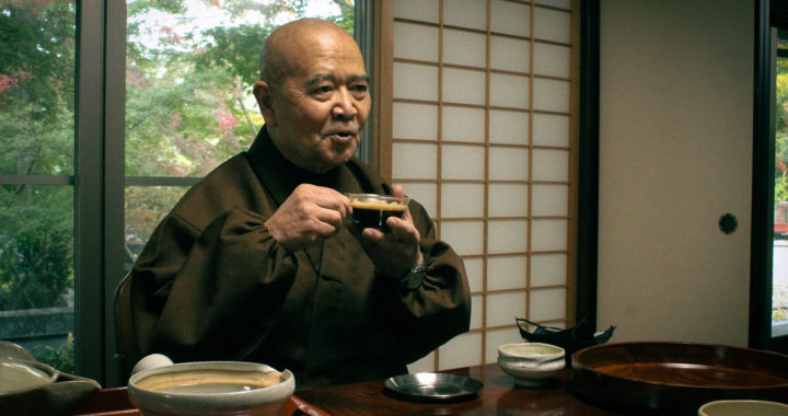 The chief abbot of Shouhouji drinks coffee while smiling.