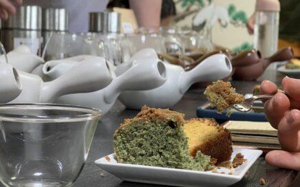 Closeup of a slice of mugwart cake with crumble in front of a row of kyusu