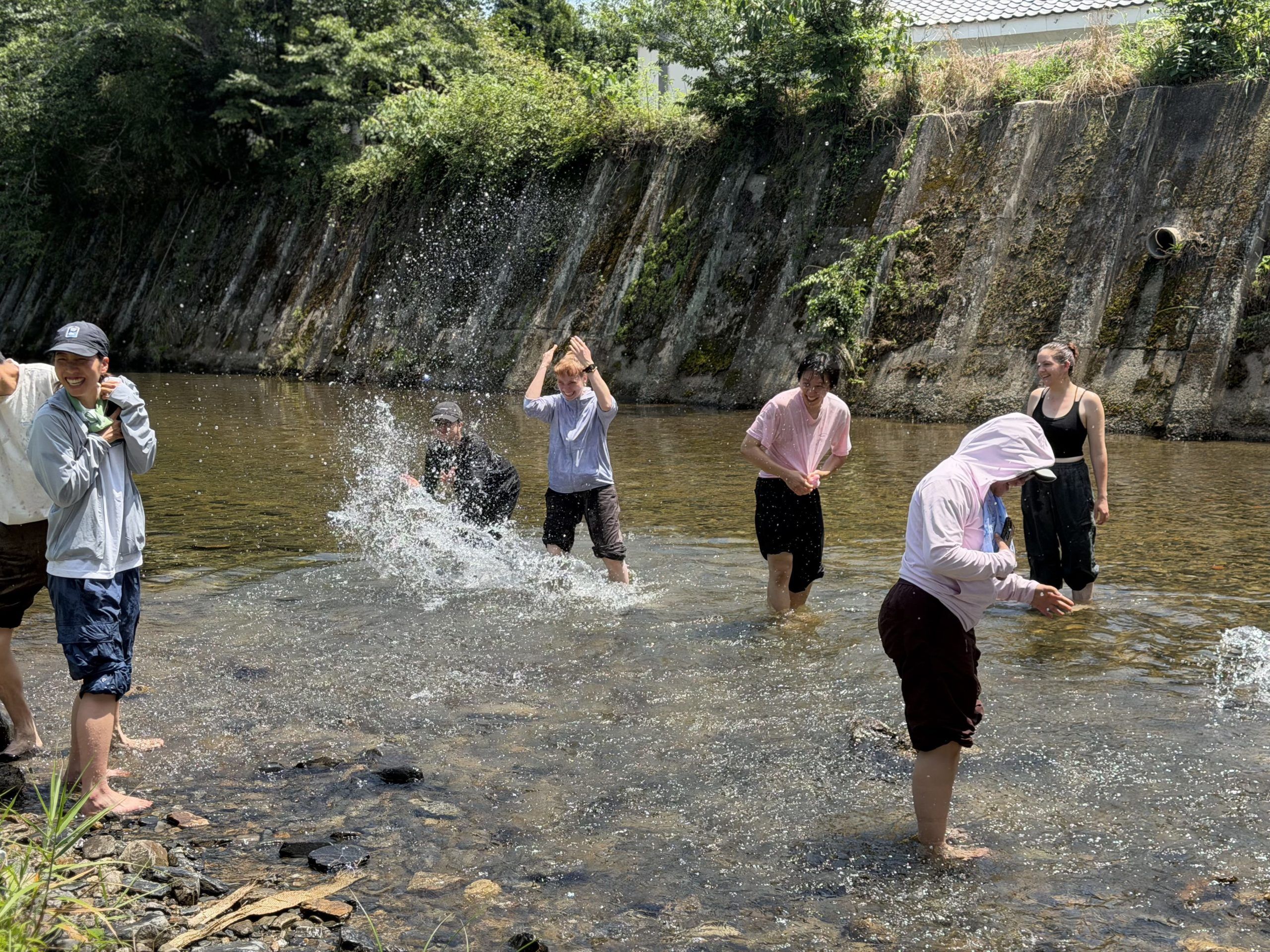 People playing in the river on a sunny day.